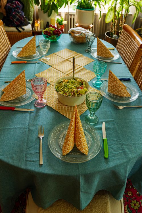 Free A beautifully set dining table with a salad centerpiece, classy glassware, and folded napkins in Coesfeld, Germany. Stock Photo