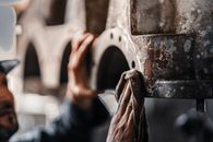 Close-up of a worker cleaning and maintaining industrial machinery in a workshop in Libya.