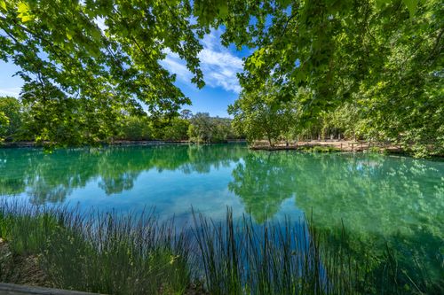 Free Serene view of a reflective lake surrounded by lush greenery in Anna, Comunidad Valenciana, Spain. Stock Photo