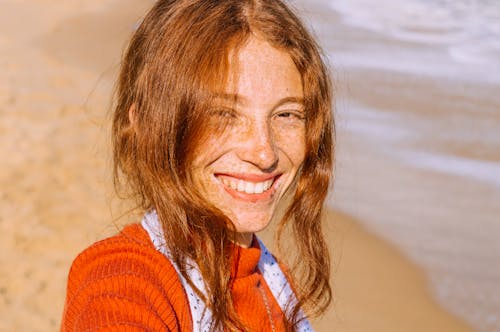 Foto Potret Wanita Tersenyum Berbintik Bintik Berdiri Di Tepi Pantai