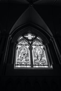 旧大教堂的黑白彩色玻璃窗下方，装饰着十字架等元素