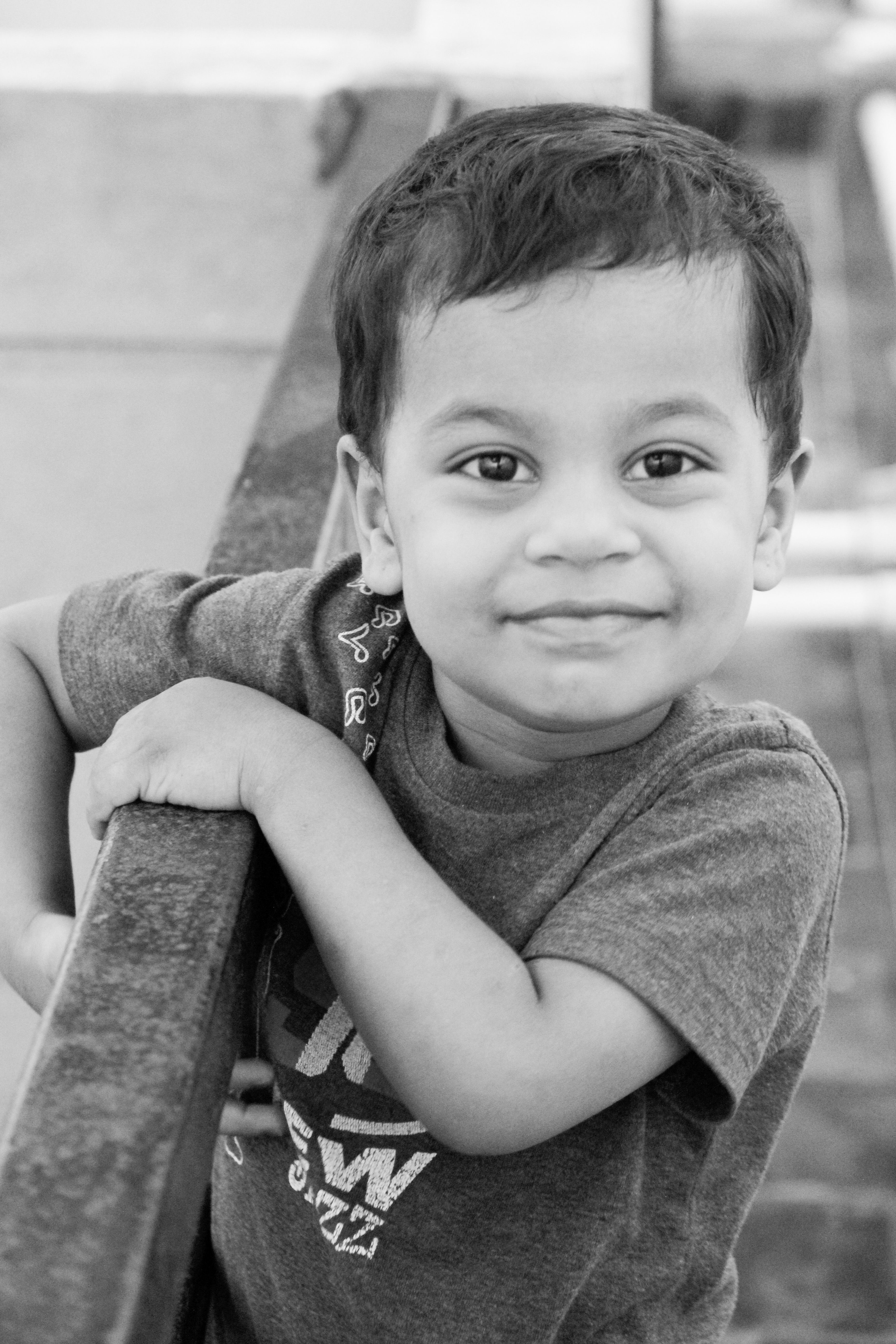 Adorable Smiling Child Holding Railing · Free Stock Photo