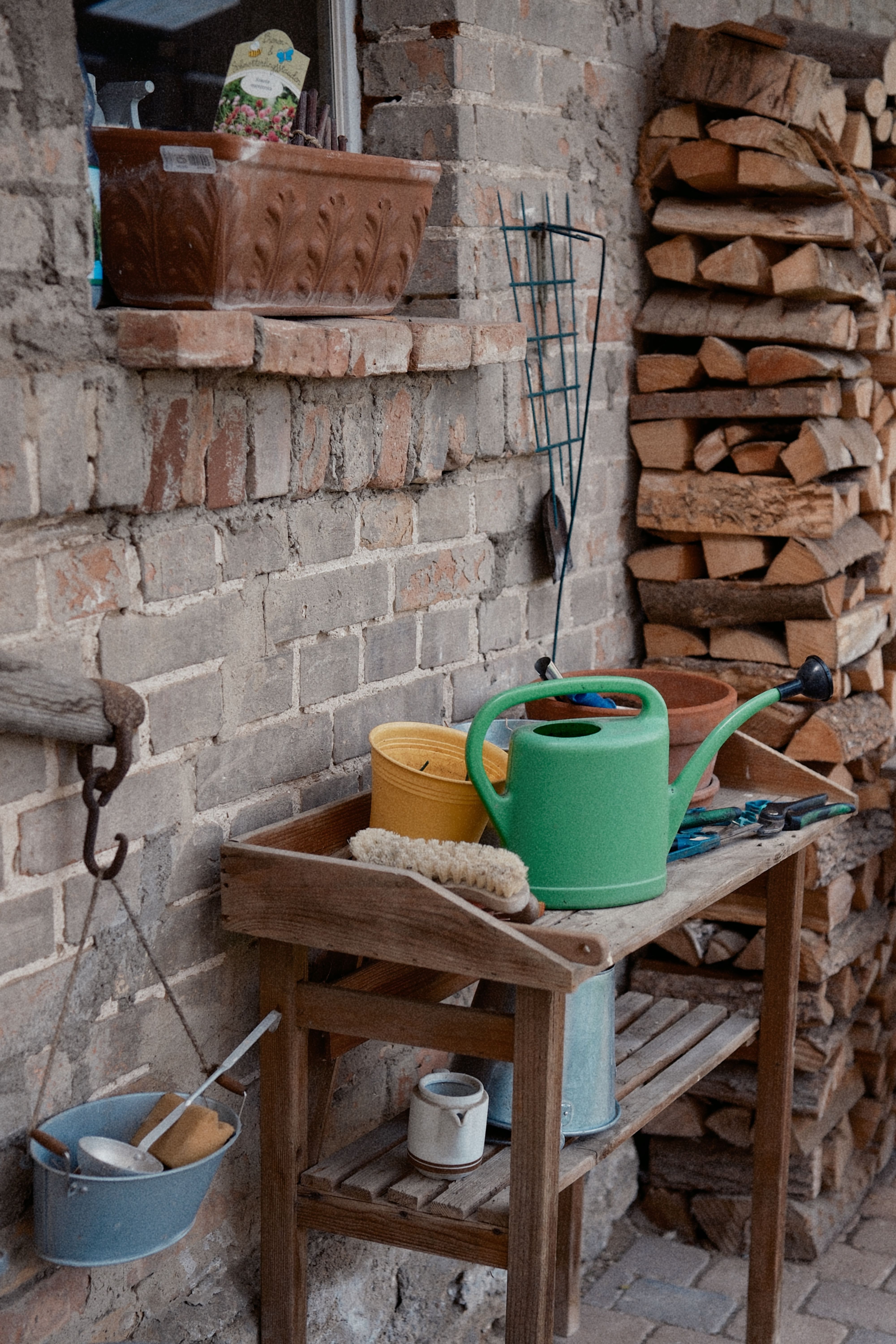 Narrow two-tier rolling cart on a small apartment patio, holding potted plants and a drink tray