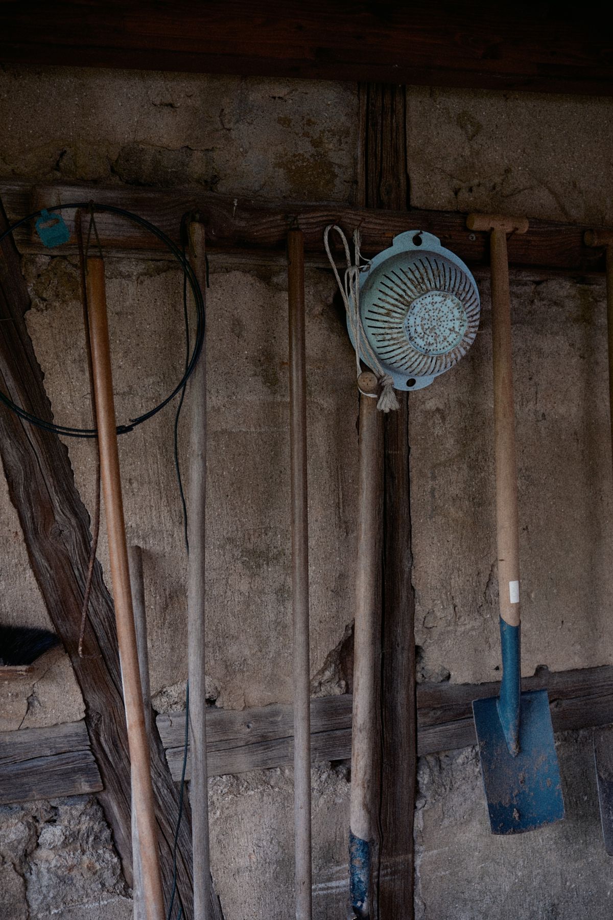 Inside of a rustic shed with gardening tools hanging on the wall