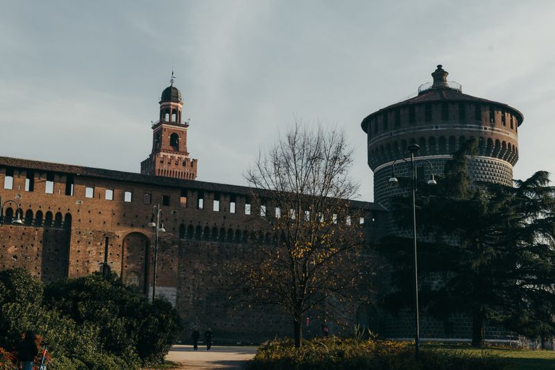 Castelul Sforzesco din Milano, în lumină de toamnă, între copaci