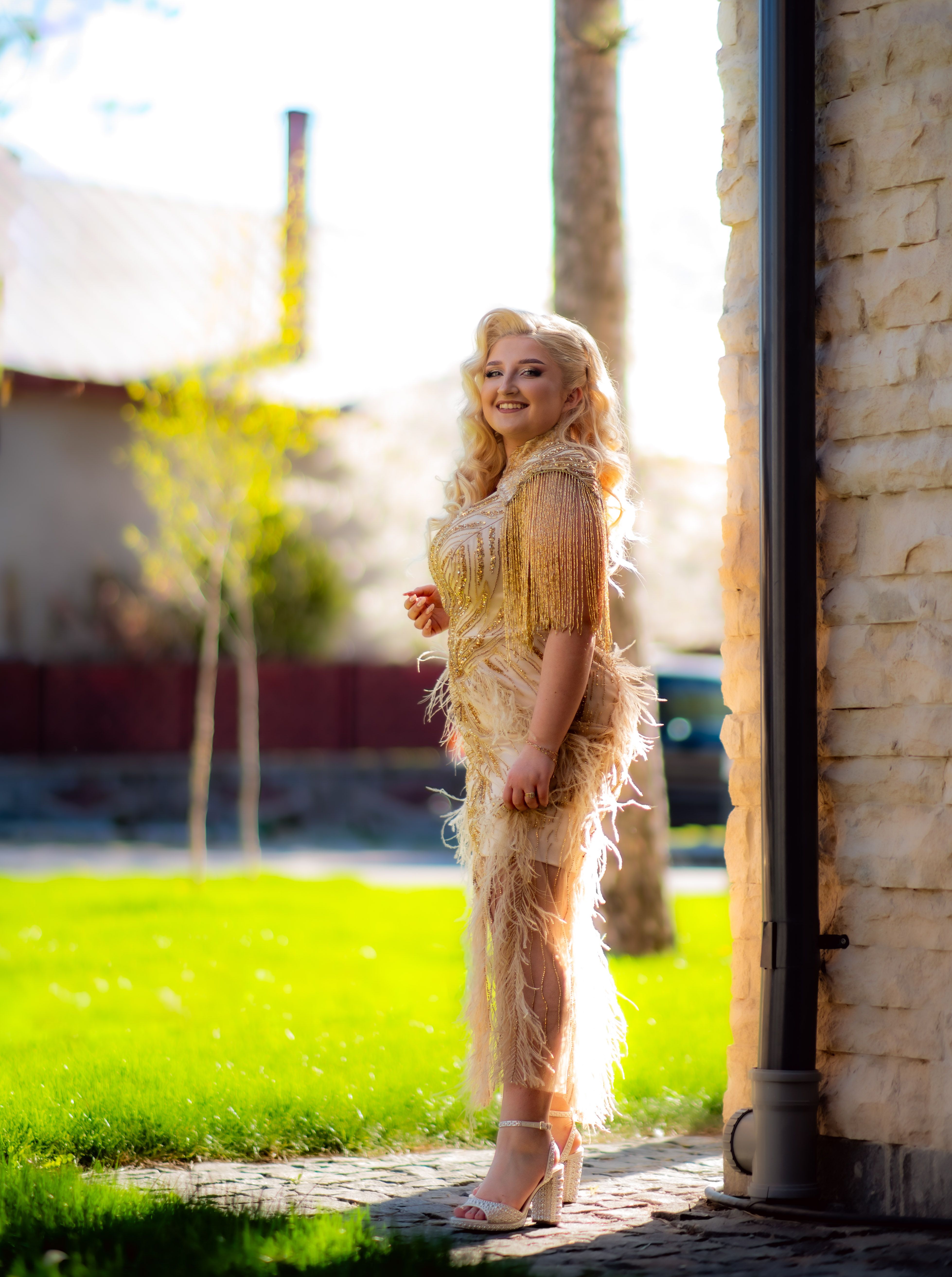 Elegant Woman in Gold Fringe Dress Outdoors