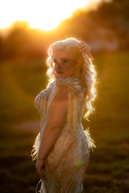 Free A glamorous woman in a beaded dress poses at sunset in Cluj-Napoca, exuding vintage elegance in the golden light. Stock Photo