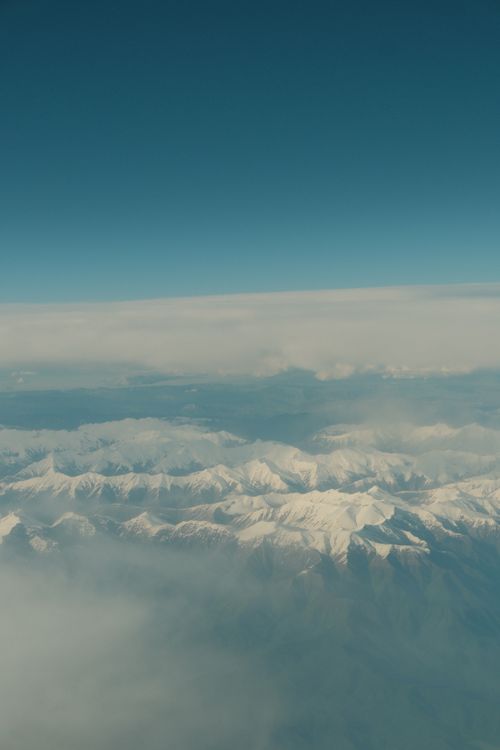 Aerial View of Snowy Mountain Range with Clear Sky · Free Stock Photo