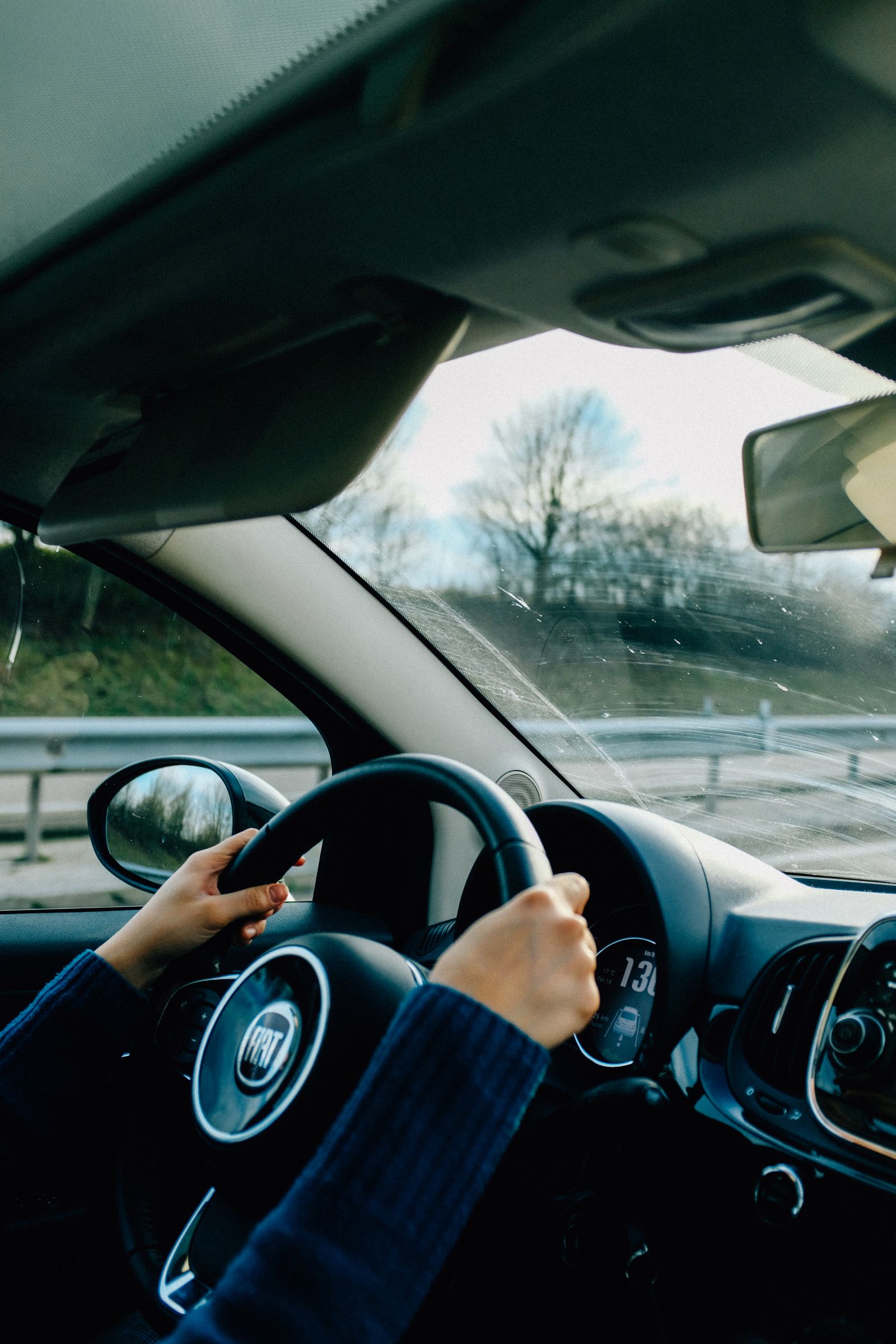Manos de un conductor sujetando el volante de un coche en marcha