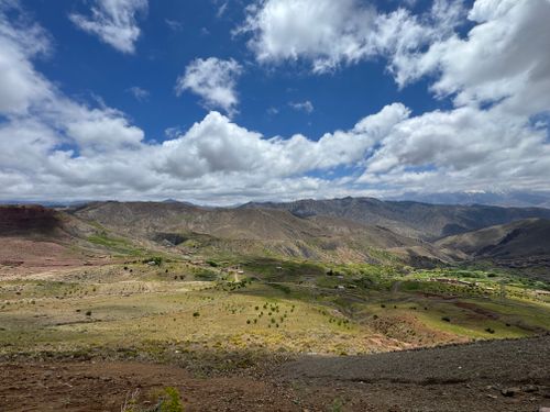 Free Expansive view of the scenic Atlas Mountains under a vibrant blue sky with fluffy clouds in Morocco. Stock Photo