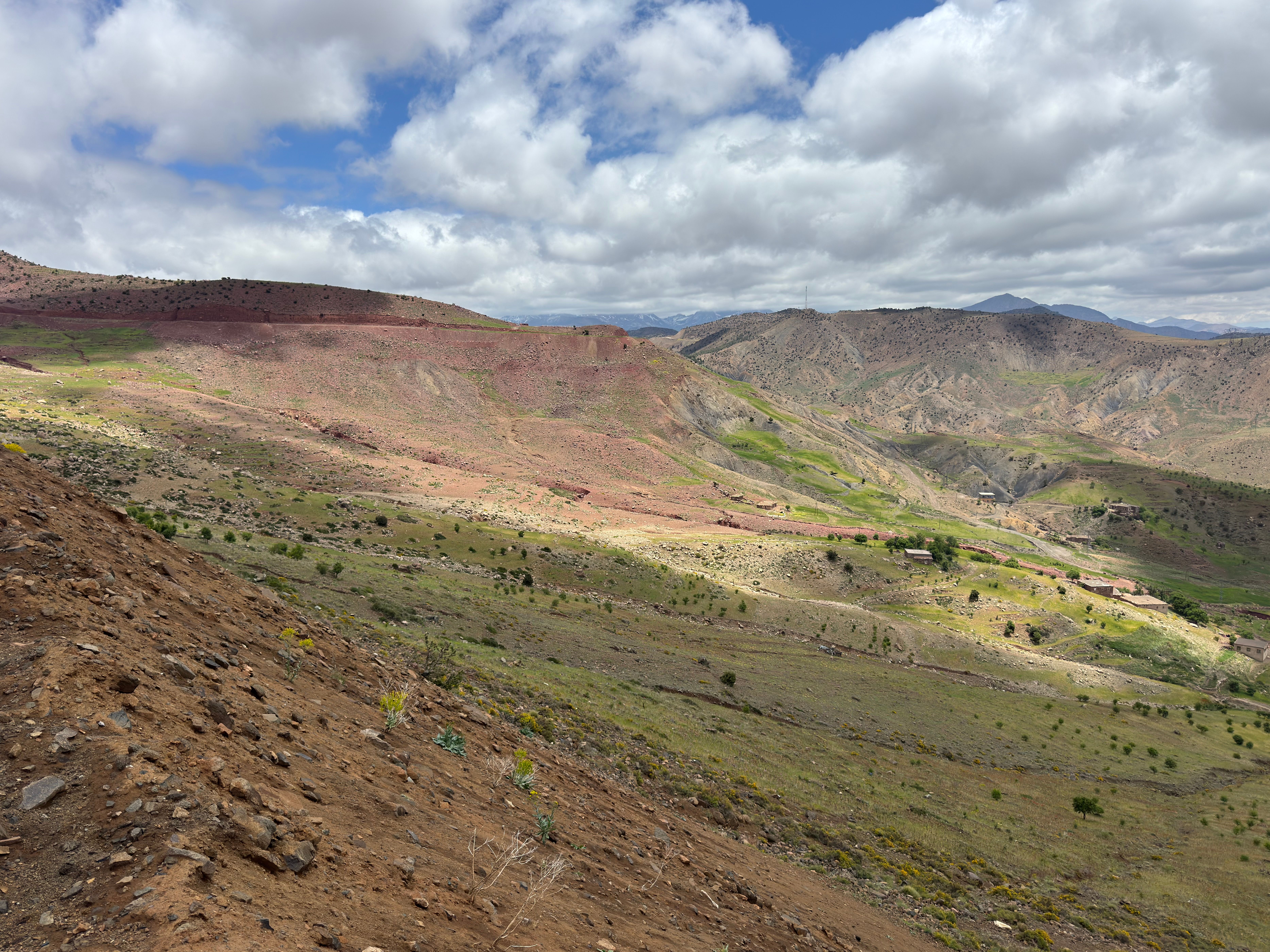 Breathtaking view of the Atlas Mountains with diverse terrain and cloudy skies highlighting natural beauty.