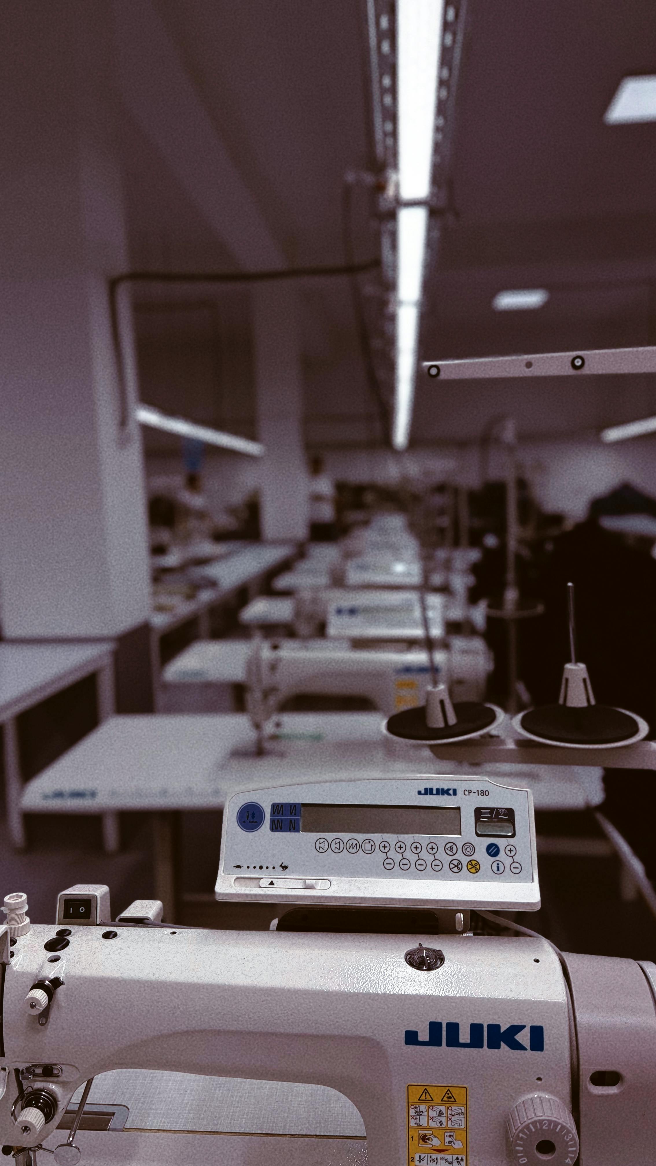 A row of industrial sewing machines in a factory setting in Uzbekistan, highlighting modern textile production.