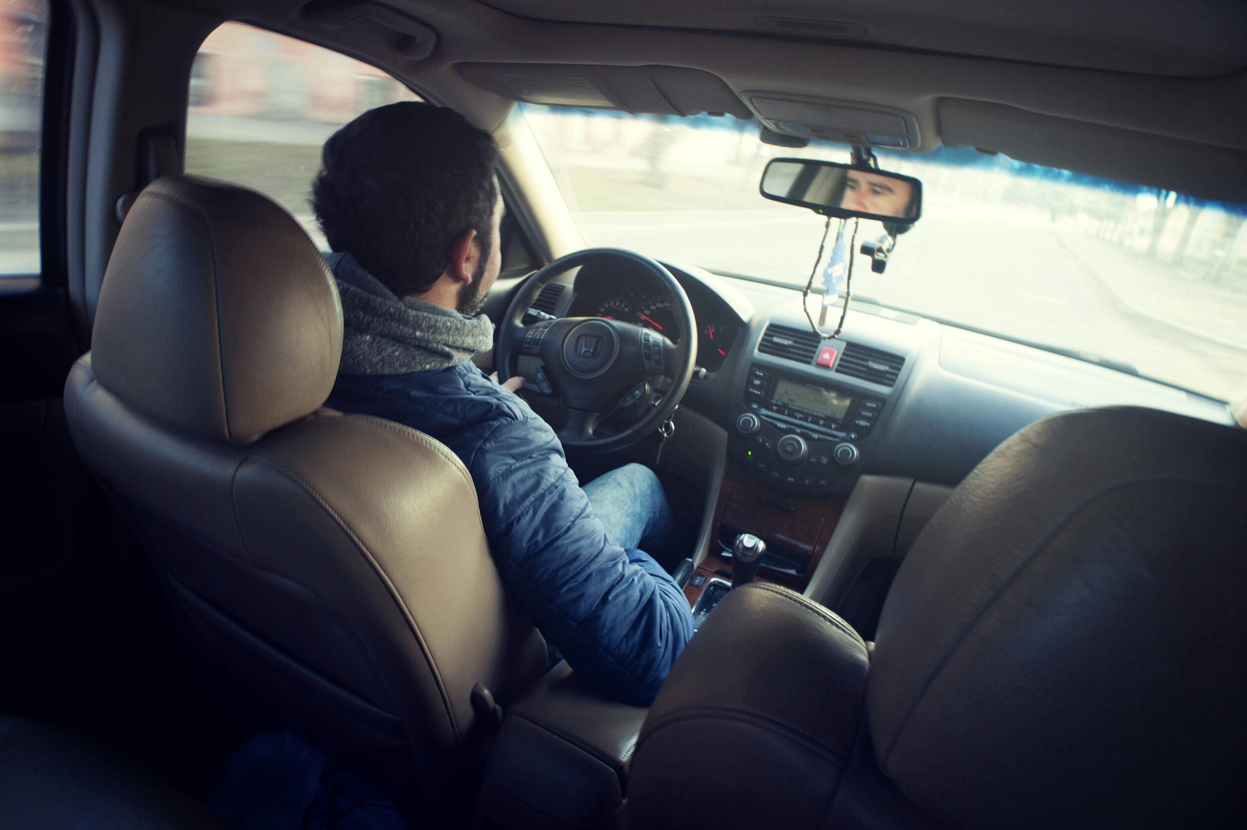 Man Wearing Blue Jacket Sitting Inside Car While Driving · Free Stock Photo