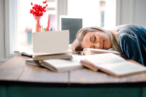 Free  Woman Sleeping on a Wooden Table Stock Photo