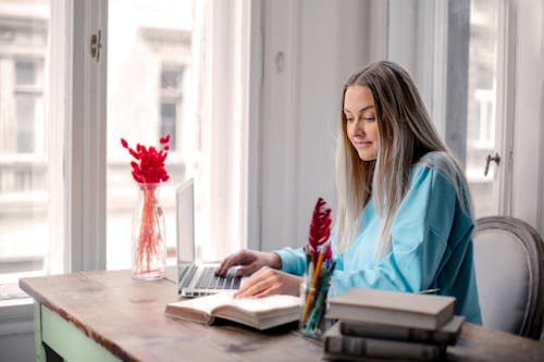 Woman in Blue Long Sleeve Shirt Sitting on Chair