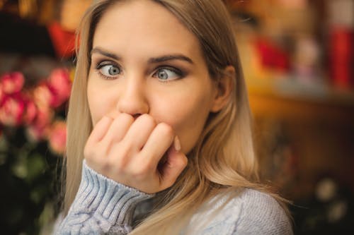 Free Woman in Gray Sweater Holding Her Face Stock Photo