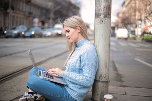 Free Woman in Blue Long Sleeve Shirt While Using Laptop Stock Photo
