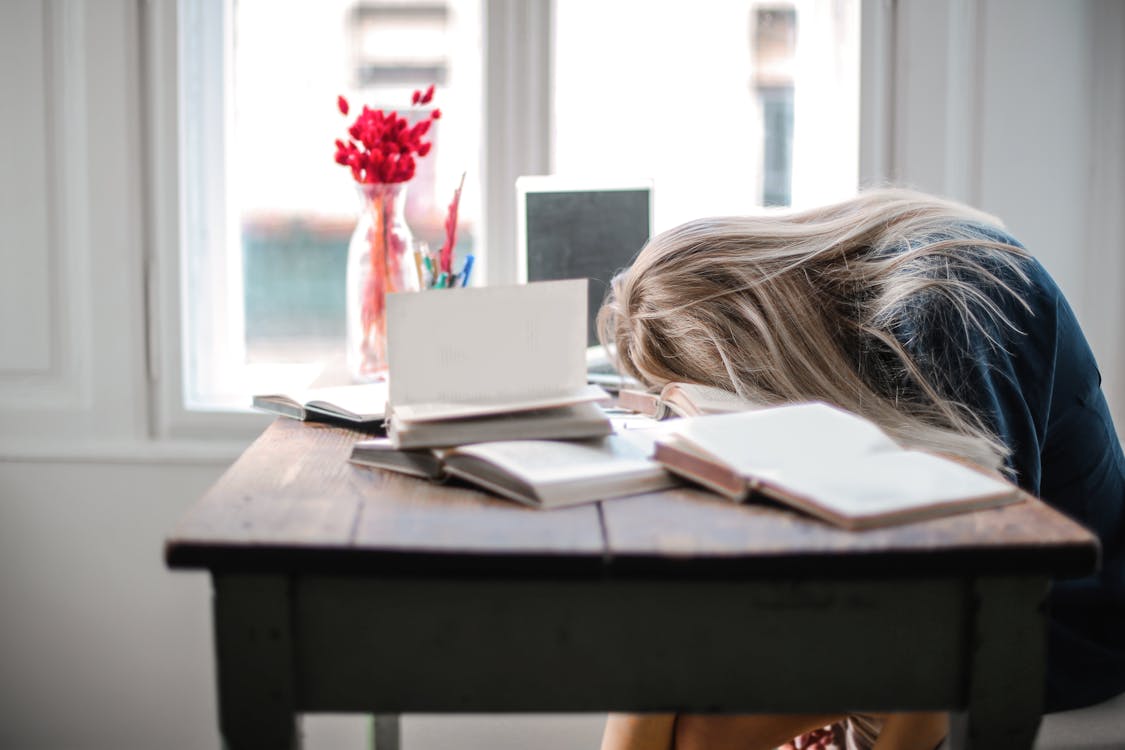 exhausted girl lying her head on desk