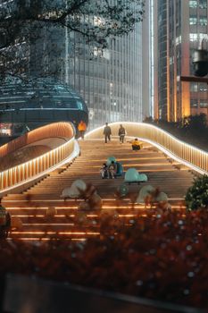 Illuminated bridge in urban China at night with people enjoying the vibrant and modern cityscape.