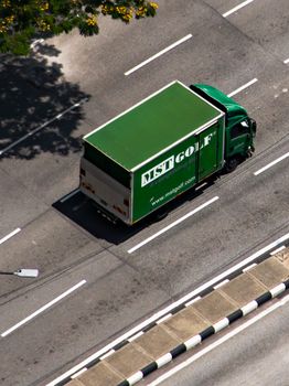 Aerial shot of a green delivery truck on a city road in Kuala Lumpur.