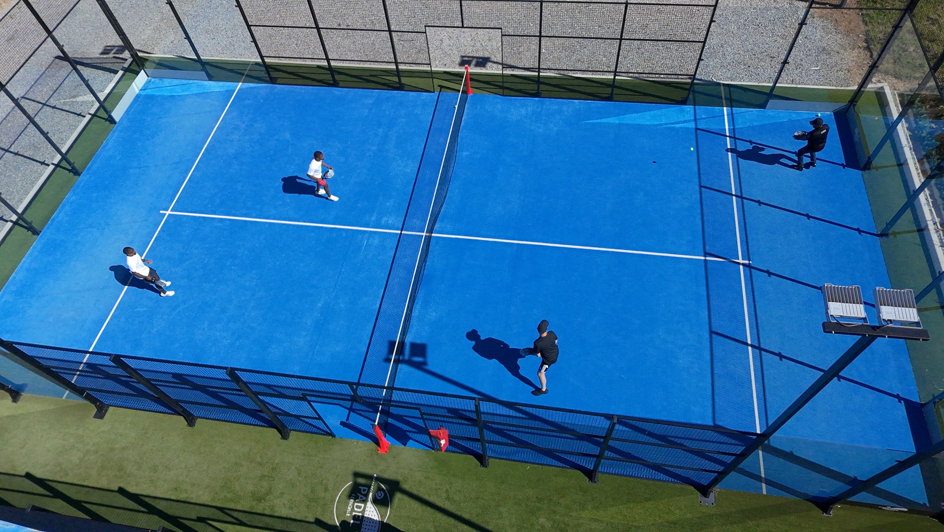 An aerial view of players on a padel court