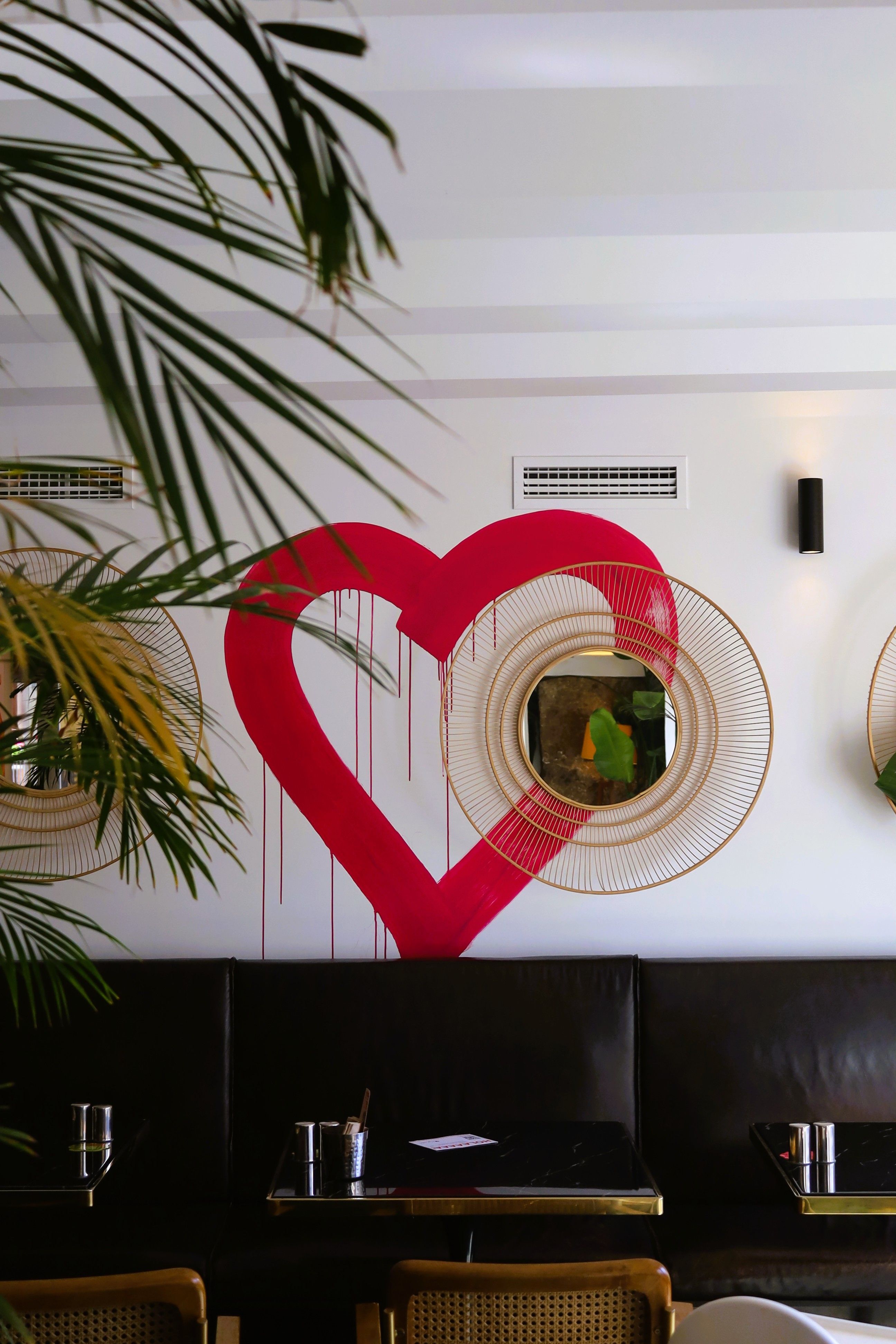 Chic urban cafe interior featuring bold heart mural and cozy seating.