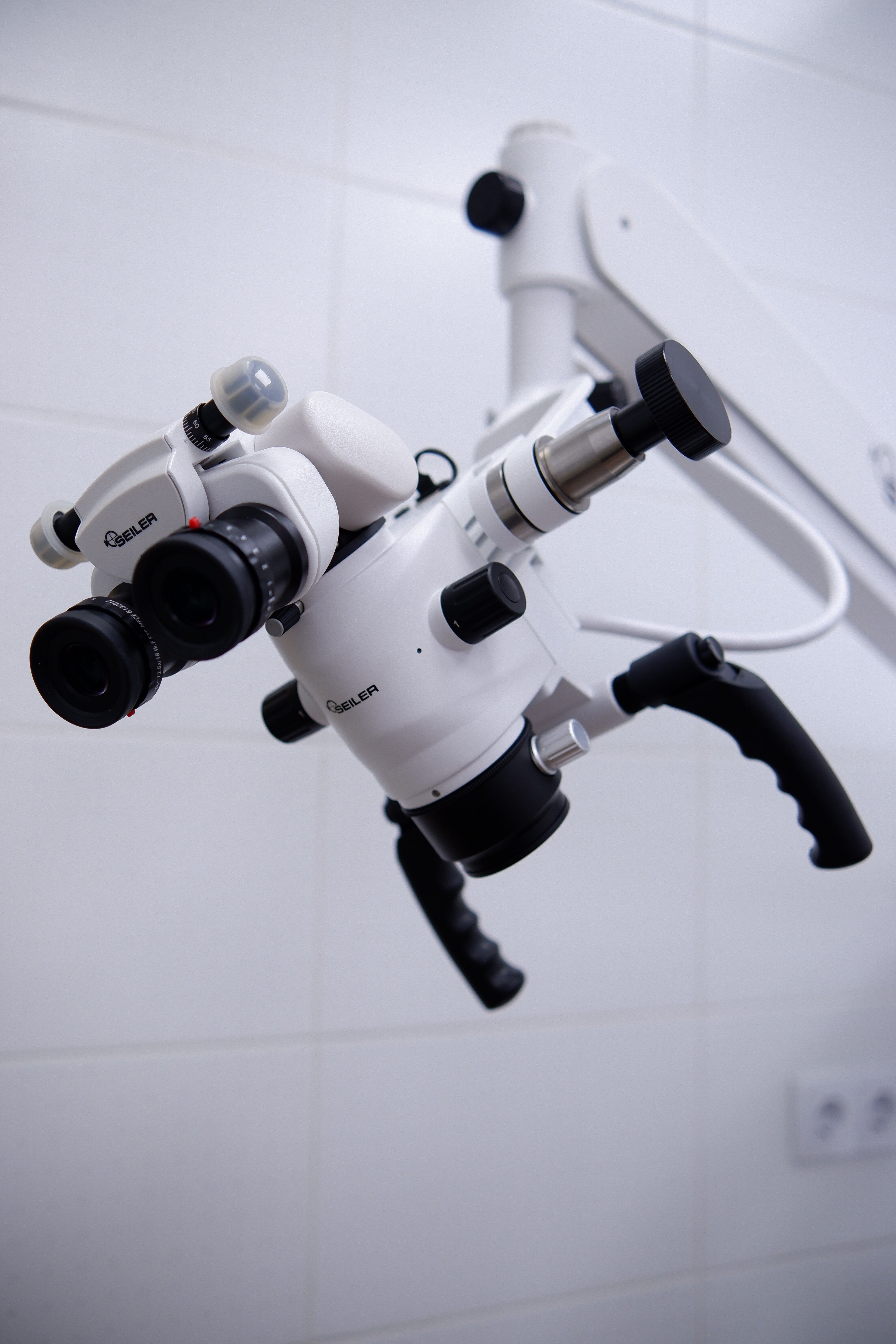 Close-up of a modern surgical microscope in a healthcare facility.