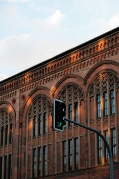 Elegant Gothic revival architecture illuminated by sunset with a traffic light in view.