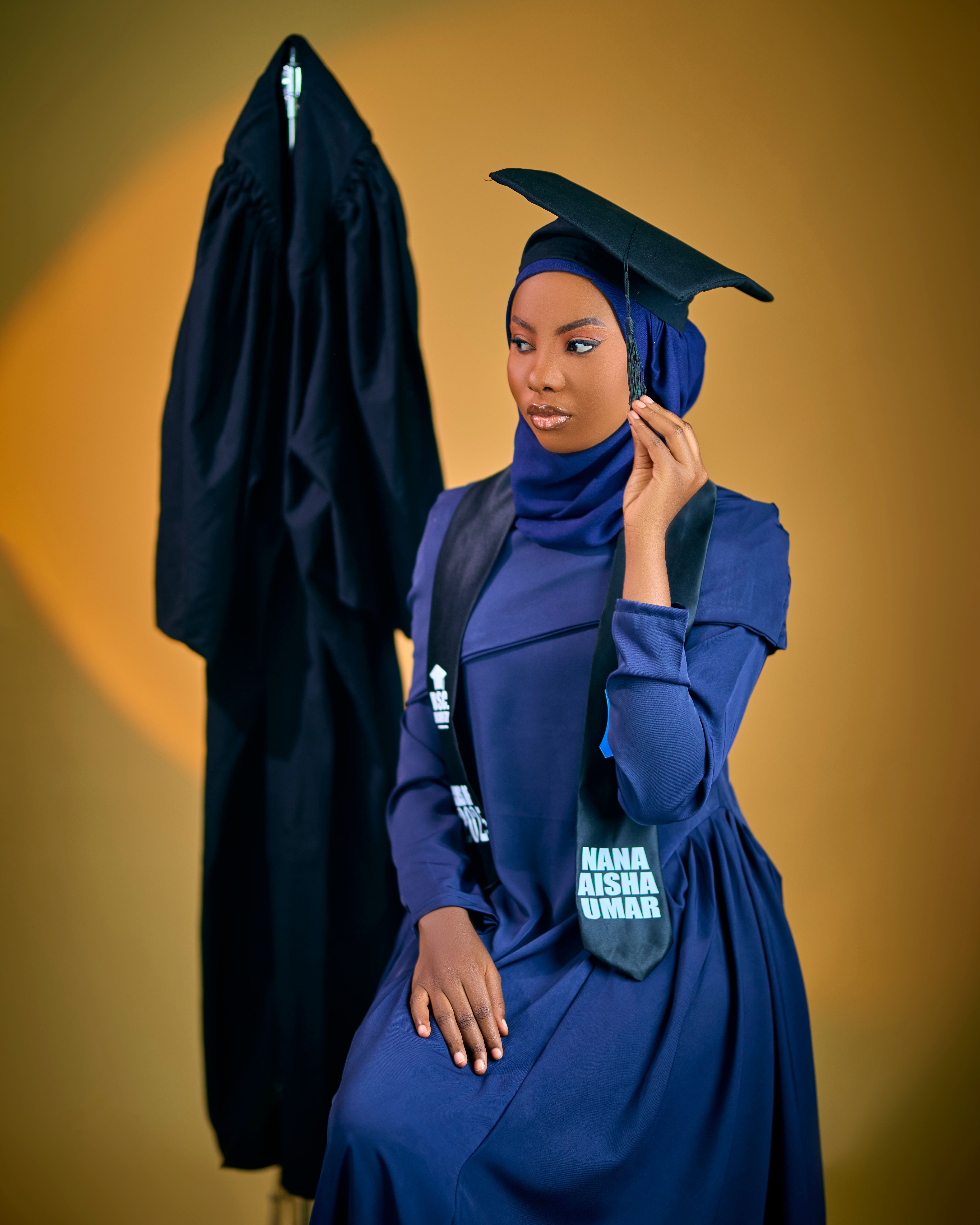 Confident young graduate wearing hijab and cap at her graduation ceremony.