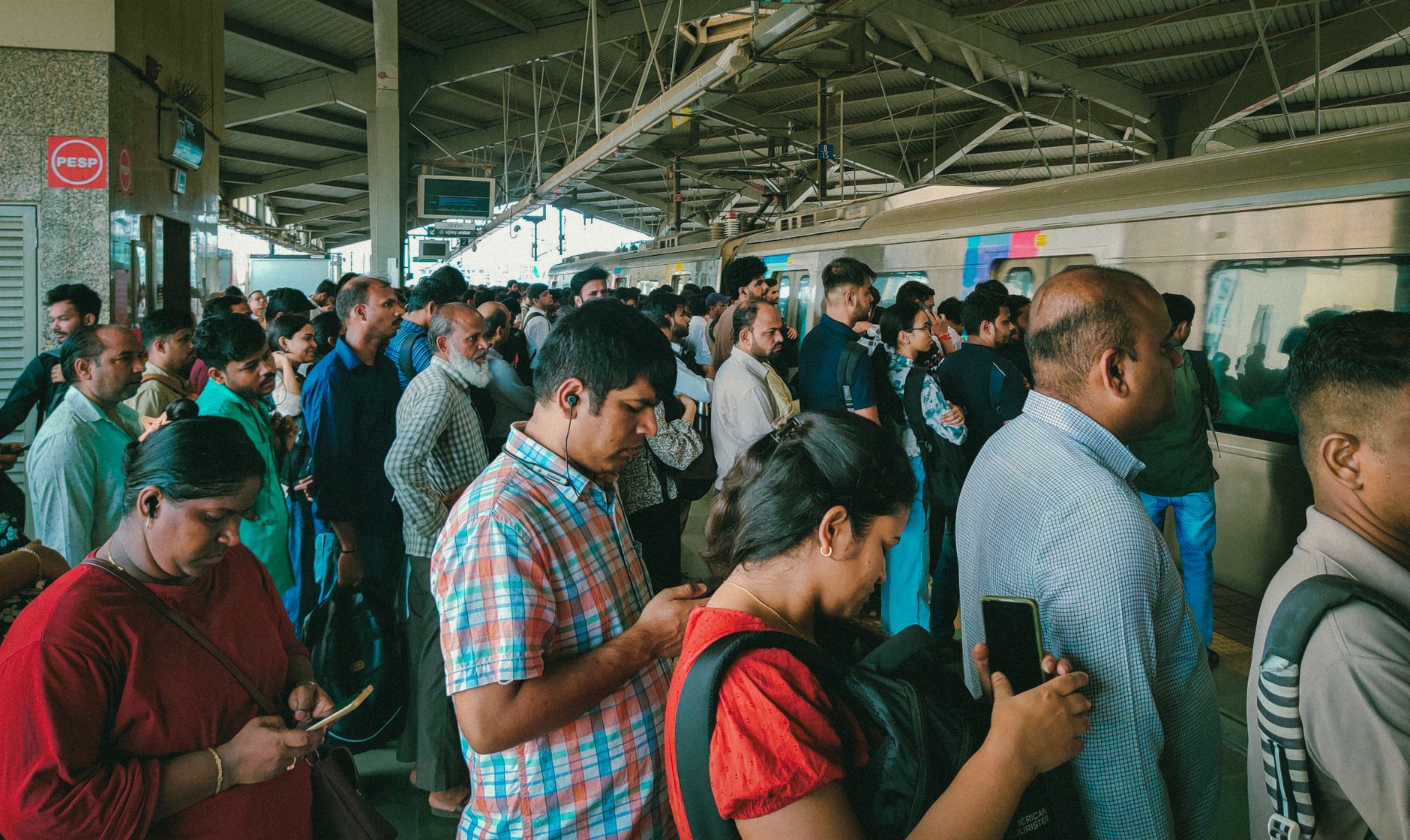 Crowded Mumbai local train passing beside monsoon-flooded streets beneath dramatic grey clouds