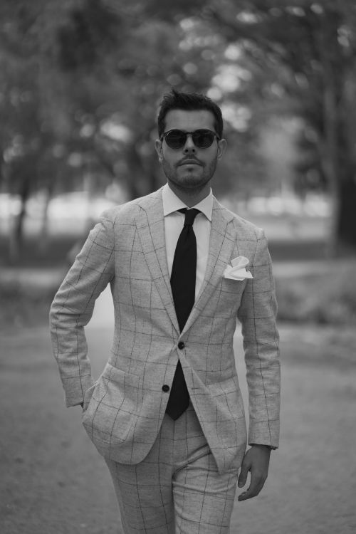 Free Monochrome portrait of a man in a suit walking confidently outdoors. Stock Photo