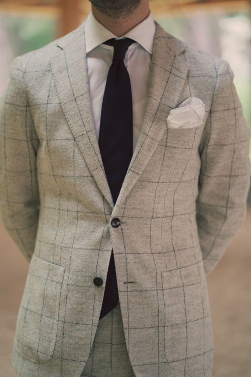 Free Close-up of a man in a stylish checkered suit with a purple tie and pocket square, embodying modern fashion. Stock Photo