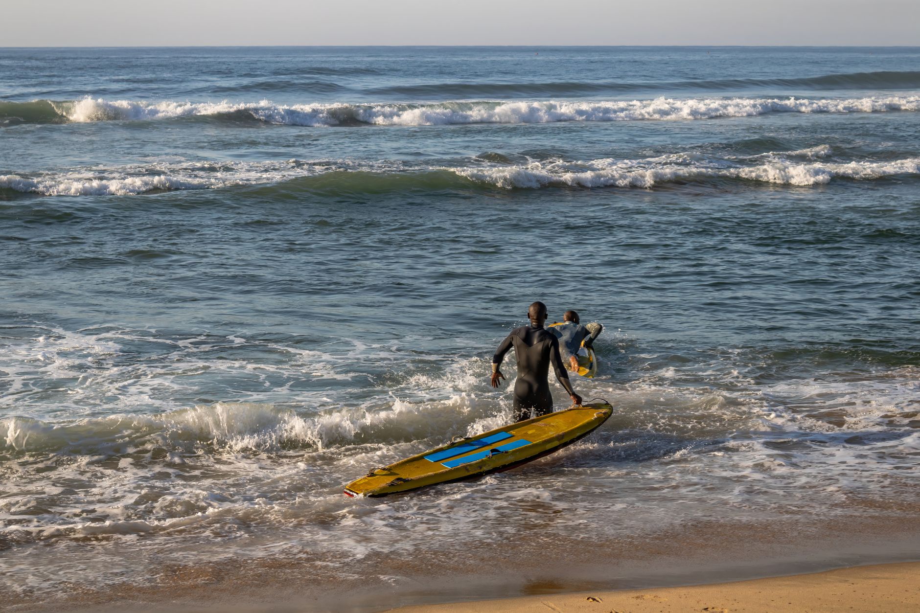 Senegal kıyısında sörf tahtalarıyla dalgalara giren genç kızlar
