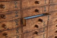Close-up of wooden drawers with Japanese characters in a Tokyo temple.