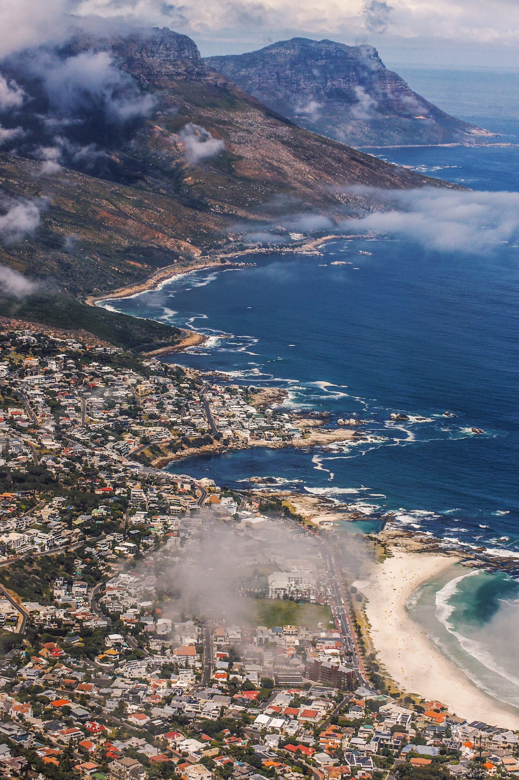Breathtaking aerial view of Cape Town's scenic coastline with mountains and ocean.