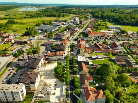 Vibrant aerial view of Garešnica with lush greenery and urban architecture under a clear summer sky.