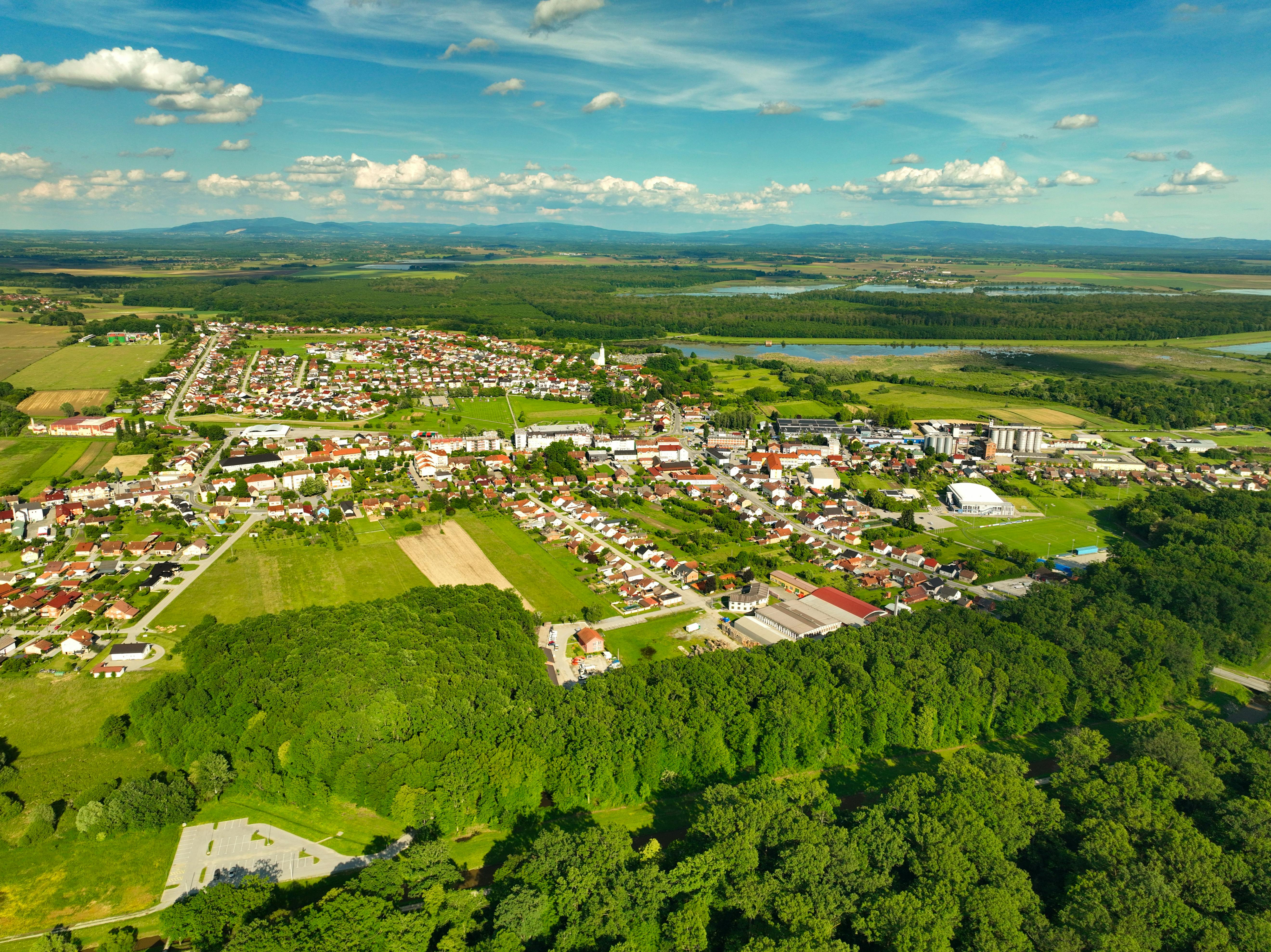 A breathtaking aerial view of Garešnica, Croatia, showcasing lush green landscapes and vibrant town architecture under a clear blue sky.