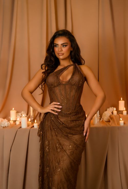 Free Chic fashion portrait of a woman in an elegant brown dress with ambient candlelight in Ferizaj. Stock Photo