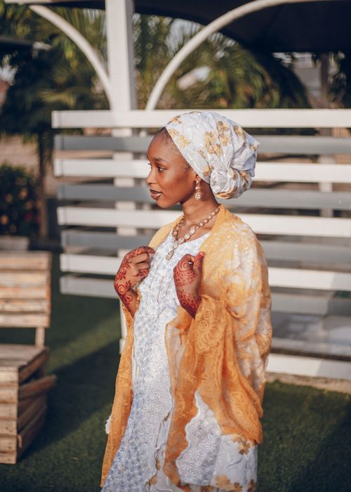 Free Portrait of a Nigerian woman in traditional attire with henna designs outdoors. Stock Photo