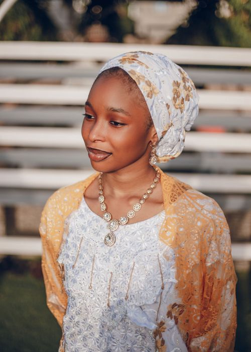 Free A beautiful Nigerian woman wears a headscarf and jewelry, exuding grace in traditional attire. Stock Photo