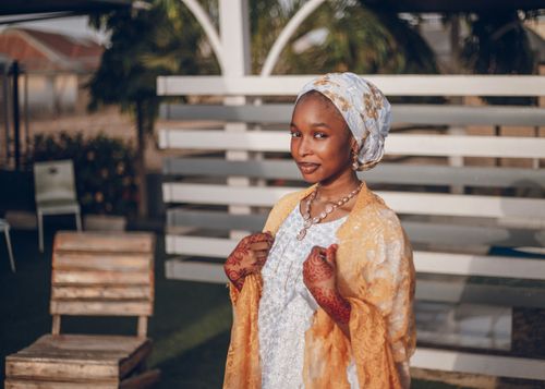 Free Portrait of a young African woman in traditional Nigerian attire with henna decorations, outdoors during the day. Stock Photo