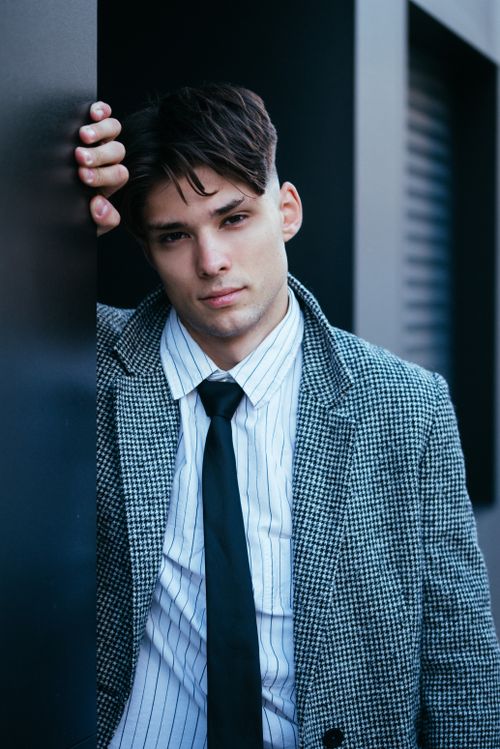 Free Stylish young man in blazer and tie looking confidently at the camera outdoors. Stock Photo