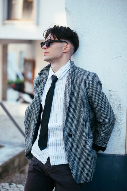 Free Confident young man in blazer and tie against urban backdrop. Stock Photo