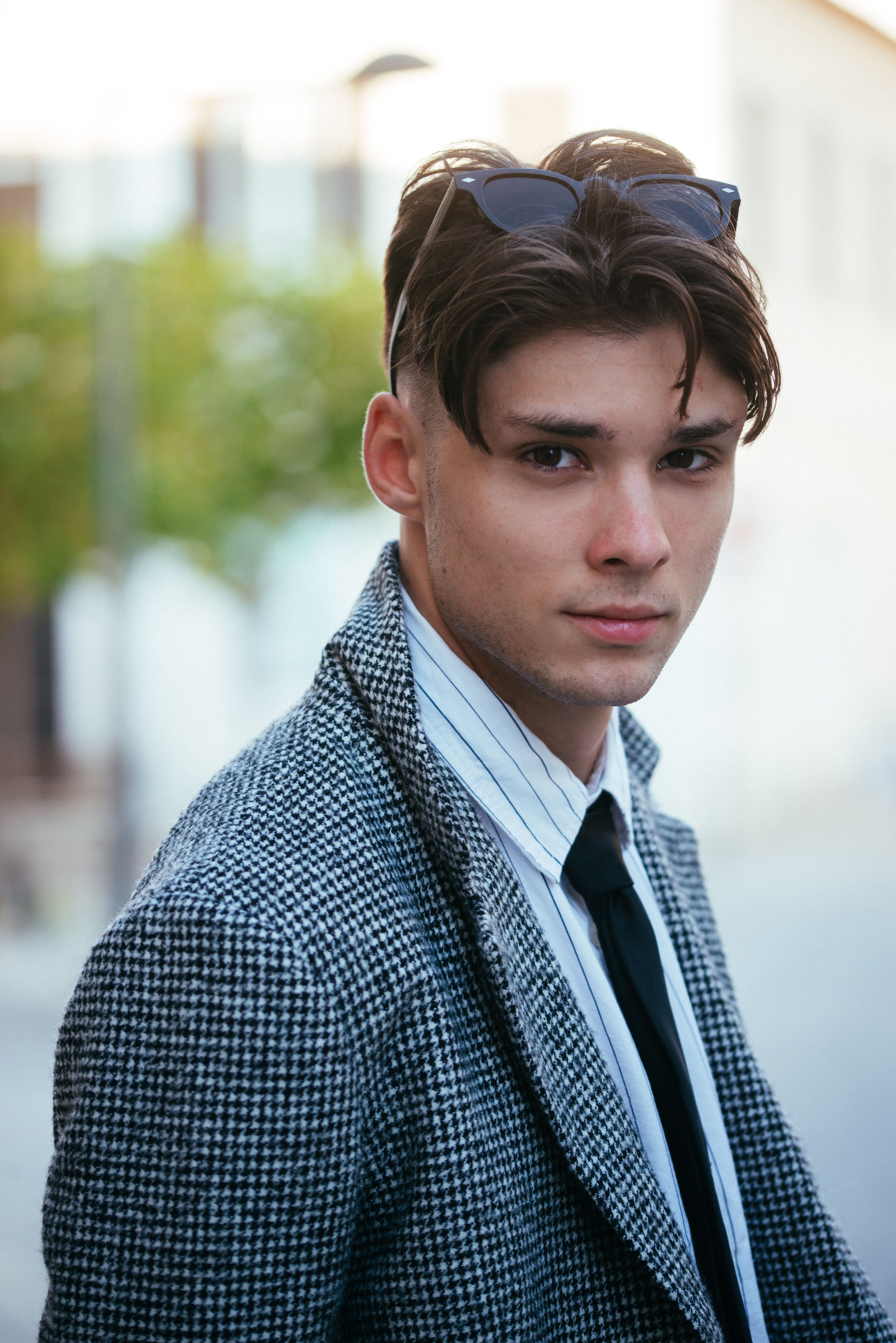 Portrait of a fashionable young man in smart casual attire outdoors.