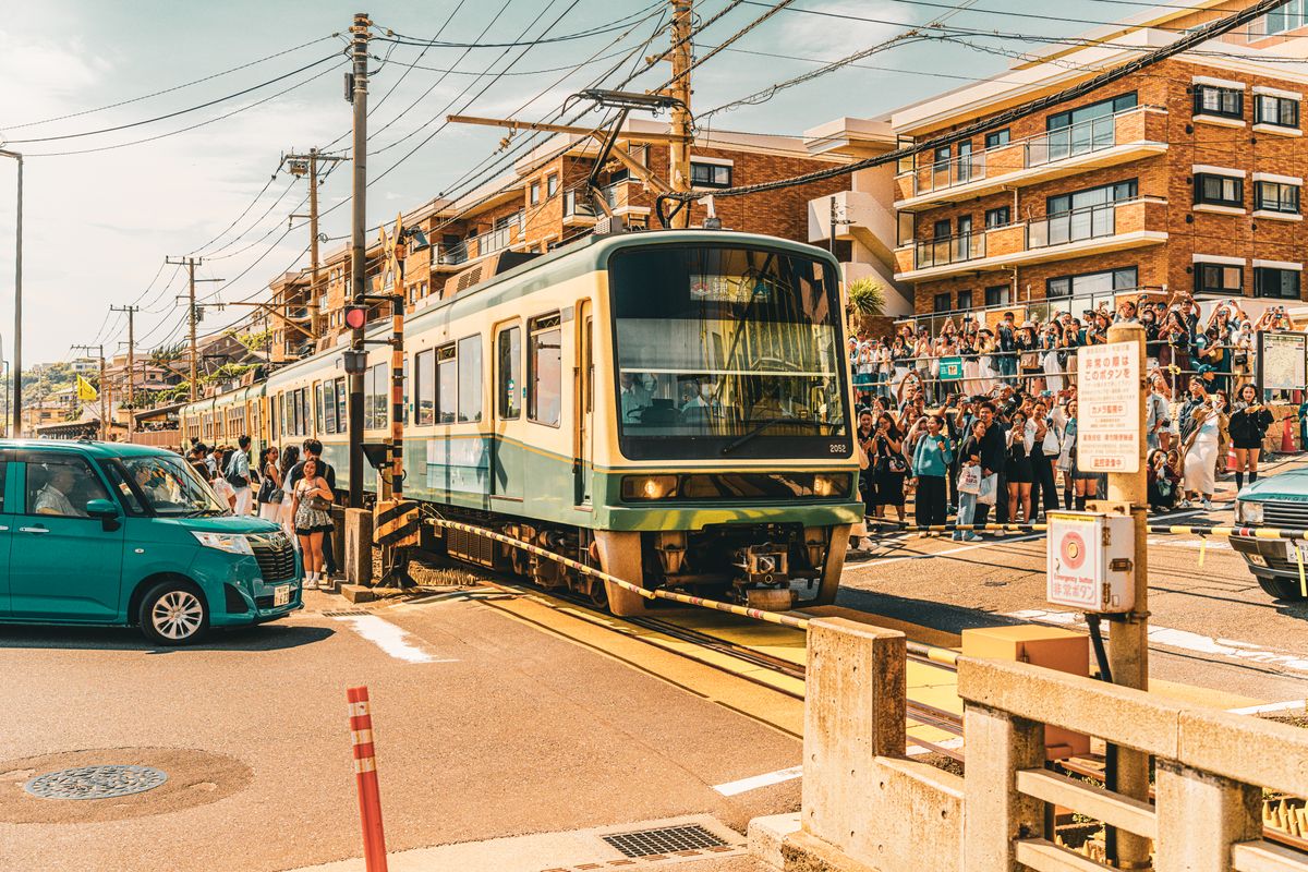 Vintage Enoden streetcar in busy Kamakura crossing on the way to Enoshima