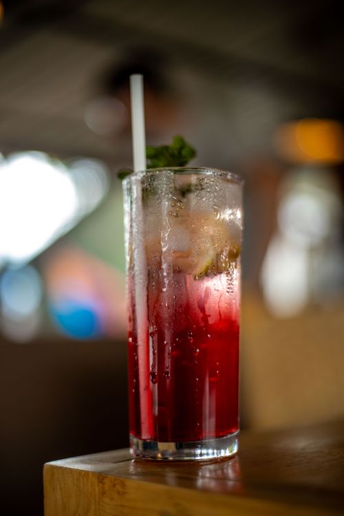 Free A vibrant red cocktail with ice and mint garnish served in a tall glass. Stock Photo