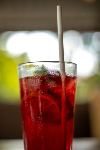 Tall glass of ruby hibiscus iced tea with citrus — photo by Mad Knoxx Deluxe on Pexels