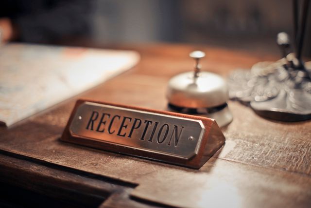 Close-up of a hotel reception desk showcasing a service bell and signage, emphasizing hospitality. Related image for AI in Hospitality: How Operators Are Using Better Data.