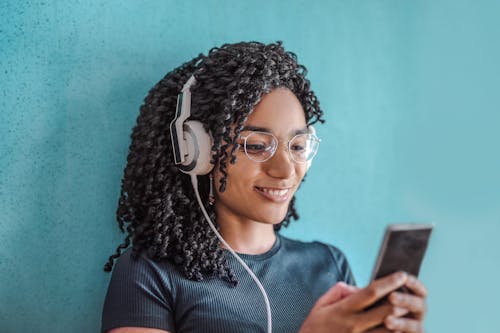 Woman in Black Crew Neck Shirt Wearing White Headphones