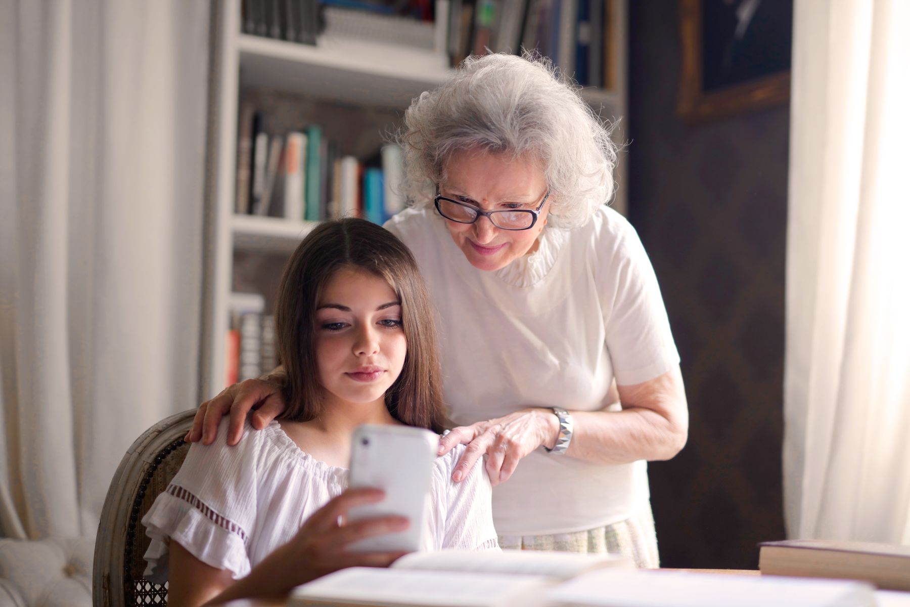 Duas gerações conversando e usando um smartphone juntas